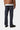 Dos d'un homme portant le Klondike Pant, un jean en coton bio Carhartt WIP bleu foncé, une veste marron et des chaussures noires.