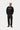 Pantalon Newel Carhartt WIP noir porté par un homme avec un sweat-shirt noir et des chaussures marron.