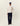 Homme portant un sweat Record Les Deux ivoire, un pantalon large bleu marine, une casquette de baseball et des mocassins marron.