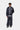 Homme portant un pantalon de survêtement Carhartt WIP Bolon bleu marine ample, avec une veste de sport assortie.