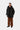 Homme portant une parka Stanwood noire Carhartt WIP, un t-shirt noir, un pantalon en velours côtelé marron et des mocassins noirs.