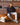 Homme portant les baskets The Re-Run Scratched The Mercer Brand, veste marine, polo marron, pantalon clair, ambiance salon.