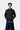 Jeune homme portant la Veste Pull Curtis Carhartt WIP gris anthracite, avec un t-shirt violet et un jean ample bleu.