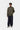 Homme portant le Curtis Sweater Jacket Carhartt WIP vert olive, un t-shirt rayé, un pantalon bleu marine et des chaussures claires.
