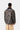 Carhartt WIP Lander Coat imprimé camouflage, vue de dos, avec col en velours côtelé noir et pantalon beige.