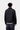 Homme portant la Veste Detroit Dark Navy Carhartt WIP, couleur camel avec col en velours côtelé marron et logo sur la poitrine.