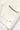 Close-up of Service Works Blanket Stitch Knit in cream, showing navy blanket stitch detail on pocket and embroidered SW initials.