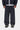 Pantalon de survêtement Bolon Carhartt WIP bleu marine, coupe ample, avec logo blanc, porté par un homme.