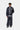 Homme portant un pantalon de survêtement Carhartt WIP Bolon bleu marine ample, avec une veste de sport assortie.