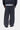 Pantalon de survêtement Bolon Carhartt WIP gris foncé coupe large, porté par derrière avec une veste et une chemise rayée.