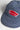 Close-up of a blue Service Works Carp Patch Cap featuring a red carp-shaped embroidered patch with 'Service Works' text.