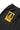 Close-up of black Service Works Classic Chef Pants, showing the yellow and black brand tag on the back pocket.