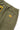 Olive green Service Works Classic Chef Pants, back view detail with elastic waistband, rear pocket, and yellow brand patch.