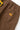 Close-up of brown Service Works Classic Chef Shorts, showing the back pocket with label and elastic waistband.