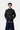 Jeune homme portant la Veste Pull Curtis Carhartt WIP gris anthracite, avec un t-shirt violet et un jean ample bleu.