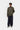 Homme portant le Curtis Sweater Jacket Carhartt WIP vert olive, un t-shirt rayé, un pantalon bleu marine et des chaussures claires.