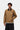 Homme portant une Carhartt WIP Detroit Jacket Hamilton Brown avec col en velours côtelé, un pull gris et un pantalon noir.