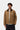 Homme portant la Veste Detroit Hamilton Brown Carhartt WIP, couleur camel avec col en velours côtelé marron et logo sur la poitrine.