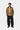 Homme portant la Veste Detroit Hamilton Brown Carhartt WIP, un pull crème en maille et un pantalon noir.