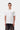 Homme portant un T-shirt blanc Carhartt WIP S/S Small Heart avec un petit cœur rouge, chaîne argentée et pantalon foncé.