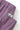 Close-up of Service Works Gardener Shorts in purple, showing the elastic waistband, brand tag, and textured fabric.