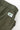 Close-up of green Service Works Gardener Shorts, showing the elastic waistband, fabric texture, and woven logo label.