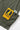 Gardener Vest by Service Works, close-up of olive green fabric with yellow 'Daily Specials' tag and white brand label detail.