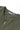 Close-up of Service Works Gardener Vest in olive green, featuring a front zipper and brand tag showing 'Service Works', size M, 'Made in India'.