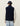 Homme portant un Gilet Teddy Les Deux bleu marine avec un patch, un pull beige et une casquette LD.