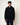 Homme portant un hoodie Homecore Terry noir texturé avec cordon à embouts rouges et un pantalon bleu foncé.