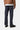 Dos d'un homme portant le Klondike Pant, un jean en coton bio Carhartt WIP bleu foncé, une veste marron et des chaussures noires.