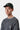 Homme portant la casquette Carhartt WIP Madison Logo verte avec un t-shirt gaufré gris et un collier argenté.