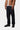 Pantalon Newel Carhartt WIP bleu brut, porté par un homme avec une veste marron et des chaussures noires.