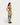 HOMECORE Pantalon Hemming M90: femme portant un pantalon à motifs géométriques camouflage vert, blanc et ocre. Vue de profil.