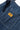 Close-up of Service Works Pinstripe Denim Apron, featuring blue fabric with white pinstripes and orange brand label.