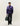 Homme portant le Pull Col Rond Forrest Les Deux violet à motif tie-dye, pantalon noir et sac de voyage vert.