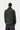 Dos d'homme portant la veste Carhartt WIP Quentin Jacket Raven/Black, col velours noir, chemise rayée et pantalon gris.