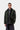 Homme portant la Carhartt WIP Quentin Jacket Raven / Black, une veste verte avec col en velours côtelé noir, sur fond blanc.