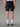 Homme de dos en Short Trail LEVICO AYAQ noir, parfait pour le trail running et les aventures en nature.