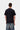 Homme de dos portant le T-shirt Carhartt WIP S/S Restraint noir uni avec des manches courtes et un jean délavé.