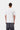 Dos d'un homme portant un t-shirt blanc Carhartt WIP S/S Restraint et un pantalon cargo gris foncé.