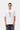 Homme portant le T-shirt S/S Restraint Carhartt WIP blanc, motif vigne, avec jeans noirs et collier.