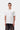 Homme portant un T-shirt blanc Carhartt WIP S/S Small Heart avec un petit cœur rouge, chaîne argentée et pantalon foncé.