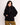 Femme souriante portant un Sweat Bangor OLOW noir en velours côtelé avec demi-fermeture éclair et pantalon kaki.