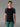 Homme portant un T-shirt 100% Mérinos BIAFO AYAQ noir avec manches raglan grises et un pantalon vert.