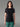Femme portant un T-shirt 100% Mérinos BIAFO AYAQ noir à manches courtes et empiècements gris, avec un pantalon vert.