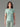 Femme portant un t-shirt technique MOLVENO AYAQ vert menthe avec manches courtes et un legging assorti.