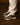 Baskets The Re-Run Americana The Mercer Brand marron, gris et beige portées avec un pantalon clair sur un sol en bois.